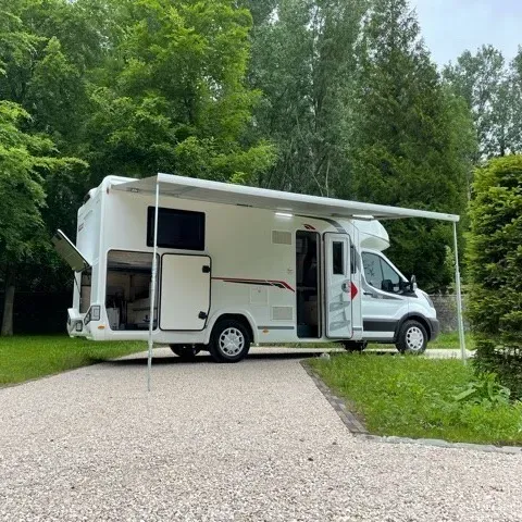 Mobilhome met luifel op een groene oprit in Gavere